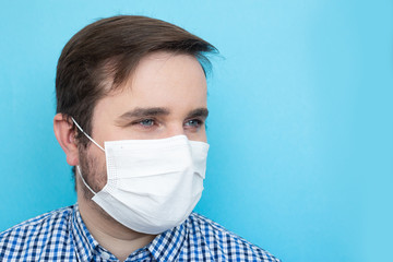 man wearing a mask to prevent germs, toxic fumes, and dust isolated on blue background, copyspace, copyplace, space for text. Prevention of bacterial infection Coronavirus