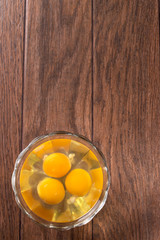 Three raw eggs in a glass bowl. The contents of chicken eggs for cooking eggs and other dishes.