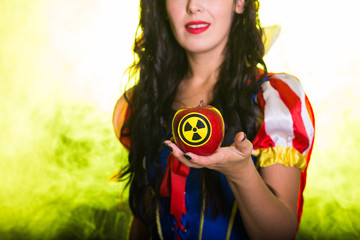 Danger, nuclear and radiation measurement - Girl holds apple with radiation hazard symbol, close-up.