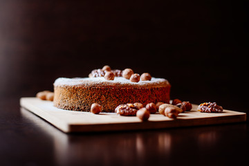 Biscuit with poppy seeds and nuts dusted with icing sugar. Homemade sponge cake with poppy seeds and nuts.