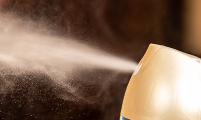 aerosol can sprays air freshener scent into a room