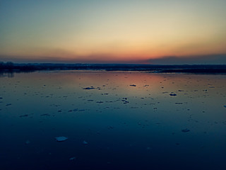 sunset over the river with floating ice floes