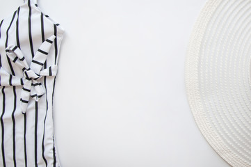 white hat and stripped swimwear flatlay on white background isolated