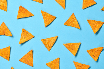 Nachos Mexican chips colorful pattern on blue background. Tortilla nacho chip closeup, fashionable trendy flat lay. Crisps nachos snack wallpaper, top view. Creative concept - obrazy, fototapety, plakaty