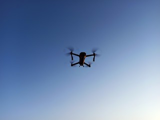quadcopter flies over the river at sunset