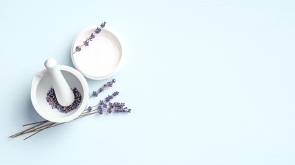 Natural face cream and mortar with lavender flowers on blue background. Organic SPA cosmetic...