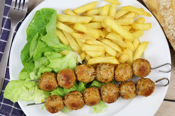 brochettes de poulet et frites dans une assiette