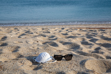 Obraz premium Protective mask on the empty beach due to Coronavirus (Covid19) quarantine. Campo nell'Elba, Italy