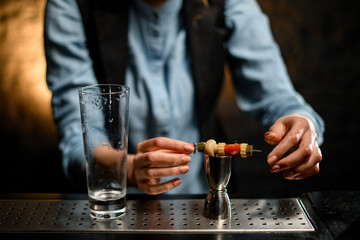 Close-up clean empty glass and metal jigger standing on bar counter.