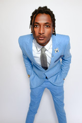 Good-looking African businessman wearing blue suit white shirt and grey tie stand