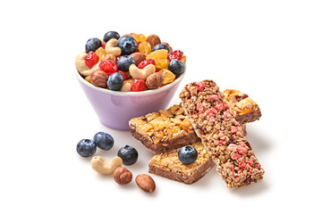 Nuts and dried fruit berries mix in bowl, granola bar. Fitness diet super food. Energy cereal healthy bar. Muesli, blueberry, seeds, hazelnut, almond, oatmeal isolated on white, closeup.
