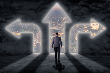 The double exposure image of the businessman standing in front of the door overlay with cityscape image. The concept of modern life, business, city life and future.
