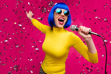 Closeup photo of funny nice lady singer party night club microphone karaoke confetti falling wear specs yellow turtleneck blue wig isolated bright pink color background - obrazy, fototapety, plakaty