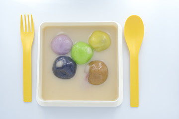 Close-up big colorful rice balls in sweet coconut milk cream, Thai dumplings in coconut milk cream, popular and famous Thailand dessert (Bua Loy)