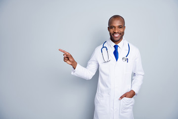 Photo of doctor handsome dark skin guy virologist family doc direct finger empty space advising use...