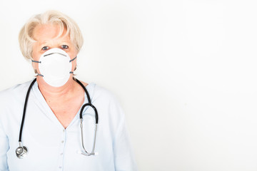 Close-up of a mature caucasian doctor with blond hair wearing a face mask to protect herself from coronavirus infection or air pollution. With stethoscope