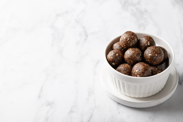 energy balls of oatmeal, nuts and dried fruits on a light gray background. Healthy eating . Place...