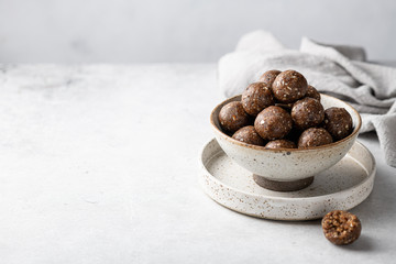 energy balls of oatmeal, nuts and dried fruits on a light gray background. Healthy eating . Place...