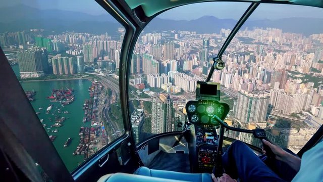 TIME LAPSE: Helicopter cockpit inside the cabin flying above Hong Kong port, New Yau Ma Tei typhoon shelter. Cargo Working Area in the waterfront of Yau Ma Tei district. Cargo ships of China.