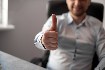 selective focus of close up photo of handsome business man giving you a thumbs up sign