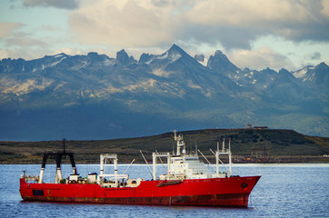 Argentinian fishing boat or whaling ship with amazing and breathtaking mountain range in Patagonia...