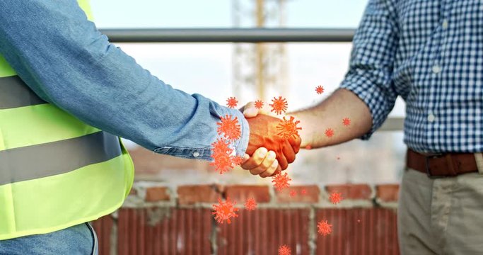 Close up of mixed-races men hands shaking outdoors at building. Spreading of coronavirus animation. Multiethnic male hands shake passing infection at construction. Spreader of pandemic virus concept.