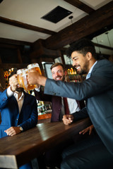 Group of happy friends drinking beer at the pub and having fun
