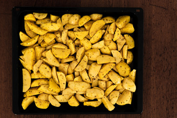 seasoned raw potatoes,baked potatoes lying in an iron pan,chopped homemade potatoes,cooking potatoes for a recipe,fast food,vegetarian food,healthy eating
