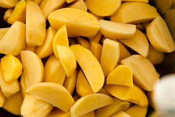 raw potatoes chopped into small pieces,baked potato,chopped potato background,yellow potato texture,seasoned potatoes,cooking baked potatoes