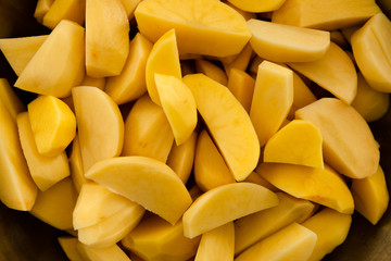 raw potatoes chopped into small pieces,baked potato,chopped potato background,yellow potato texture,seasoned potatoes,cooking baked potatoes