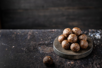 homemade chocolate sweets from nuts, dried fruits and cocoa on a dark background. Place for text