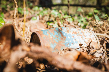 old rusty metal bucket on the ground in the forest