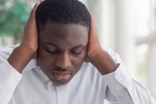 African black man covering his ears; African black man displaying concept of censorship, free speech limitation, news manipulation, hidden truth, secret, information manipulation, problem cover up