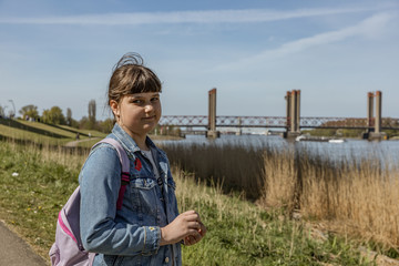 Close up portrait of caucasian smiling girl outside, traveler with backpack in Europa