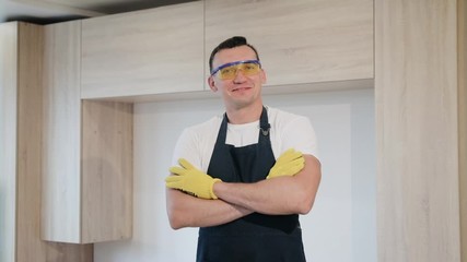 Portrait of small business owner carpenter smiling and standing in apartment with new just made furniture by himself