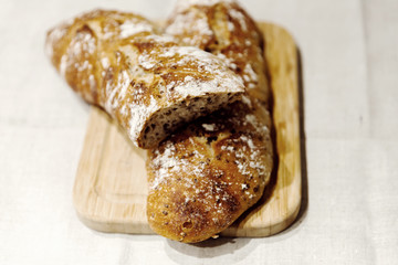 fresh bread on linen,bread lies on a cutting board,baked bread lies on the table,sliced ​​bread on linen background,home baked loaf,home made bread