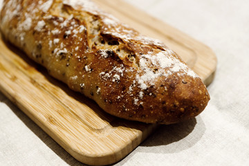 fresh bread on linen,bread lies on a cutting board,baked bread lies on the table,sliced ​​bread on linen background,home baked loaf,home made bread