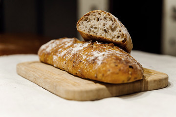 fresh bread on linen,bread lies on a cutting board,baked bread lies on the table,sliced ​​bread on linen background,home baked loaf,home made bread