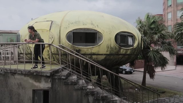 Urban Explorer Asian Girl Walking Upstairs To Abandoned UFO-shaped House