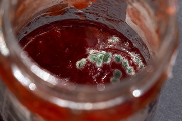 a red jam with mold on the surface