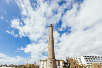 Maspalomas city lighthouse. Landscape on urban center in Canary Island. Travel and holidays concept. Summer vacations in the touristic destination Maspalomas. Tourism in spanish Canary islands.