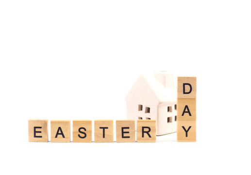 Concept image a wooden block text " EASTER DAY " with house isolated on white background with copy space for text.Symbol of Christian tradition.