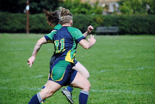 Sports woman racing down pitch