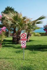 Forbidden to play ball in the grass or garden. Prohibited dogs. Prohibition signs in a garden by...