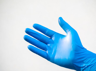 Close up hand in blue glove on white background.