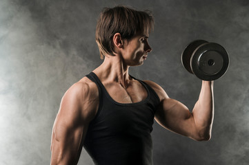 Side view of muscular man holding weight