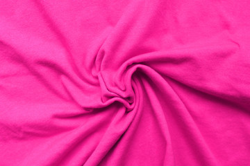 Obraz premium Creased violet cloth texture background. Blank wrinkle textile material, colorful creased purple sheet, close up top view of crumpled cloth. Uneven surface with spiral wrinkles pattern