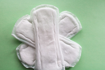 three female pads on a green background