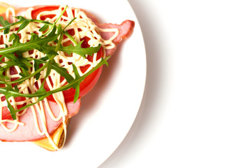 Sandwich of bread for toast, sturgeon, tomatoes, arugula, cheese and mayonnaise on a white plate in the view from the top flat lay, copy space