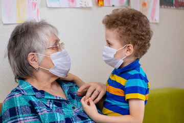 Grandmother and grandson in protective medical masks. Quarantine during the epidemic, protection of...